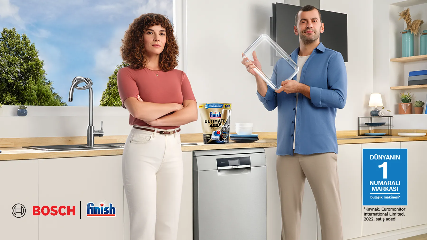 Bir mutfakta iki kişi, bir tablet tutuyor, diğeri kolları geçti, Bosch ve Bit ürünleri görünür.