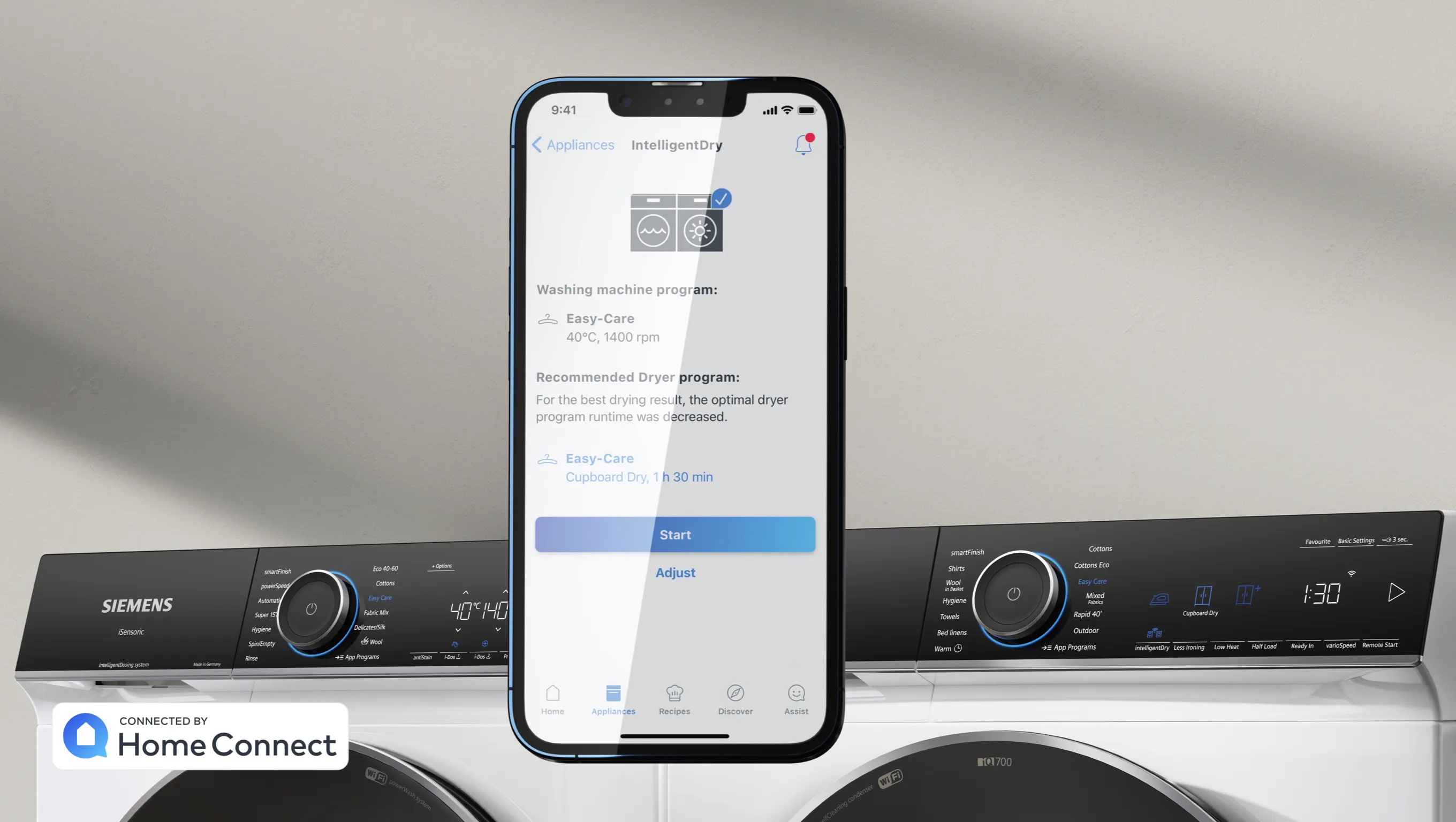 Smartphone displaying smart home app, washing machine, and dryer in modern home appliance setup.