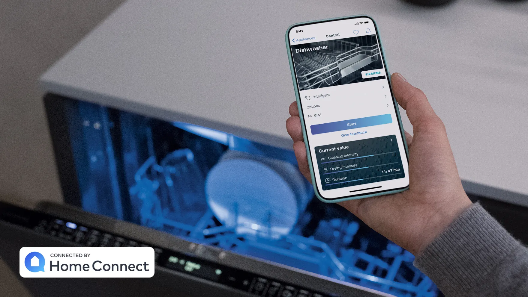 Smartphone displaying Home Connect app, laptop with blue screen, hand holding device.