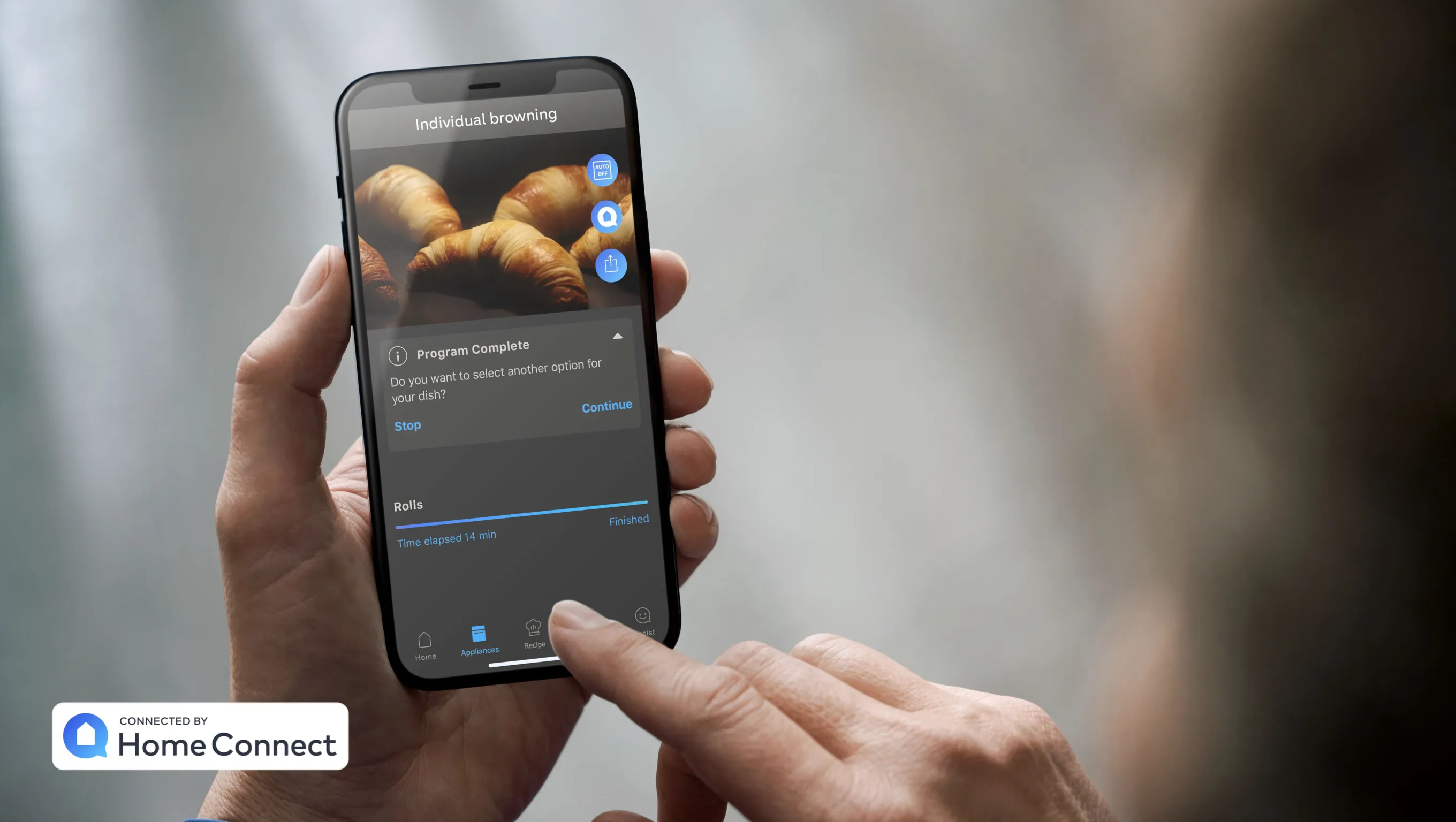 Person holding smartphone displaying croissants and Home Connect app interface.