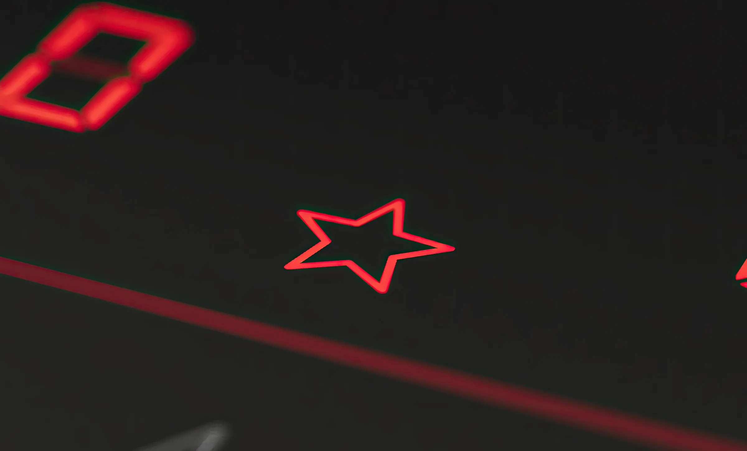 Bosch Kochfeld mit Touch-Bedienfeld. Eine Nahaufnahme einer rot leuchtenden Sterntaste für Favoritenfunktionen auf der schwarzen Glasoberfläche, oben links ist der Ansatz einer digitalen Ziffernanzeige zu sehen.