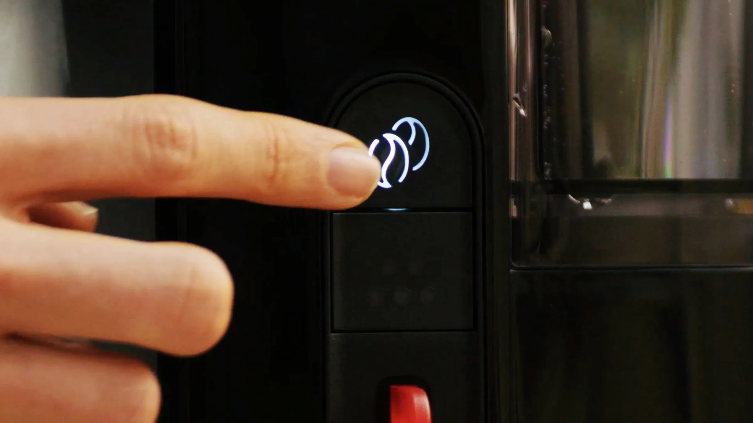 Hand pressing Aroma Intense button on MyMoment coffee maker.