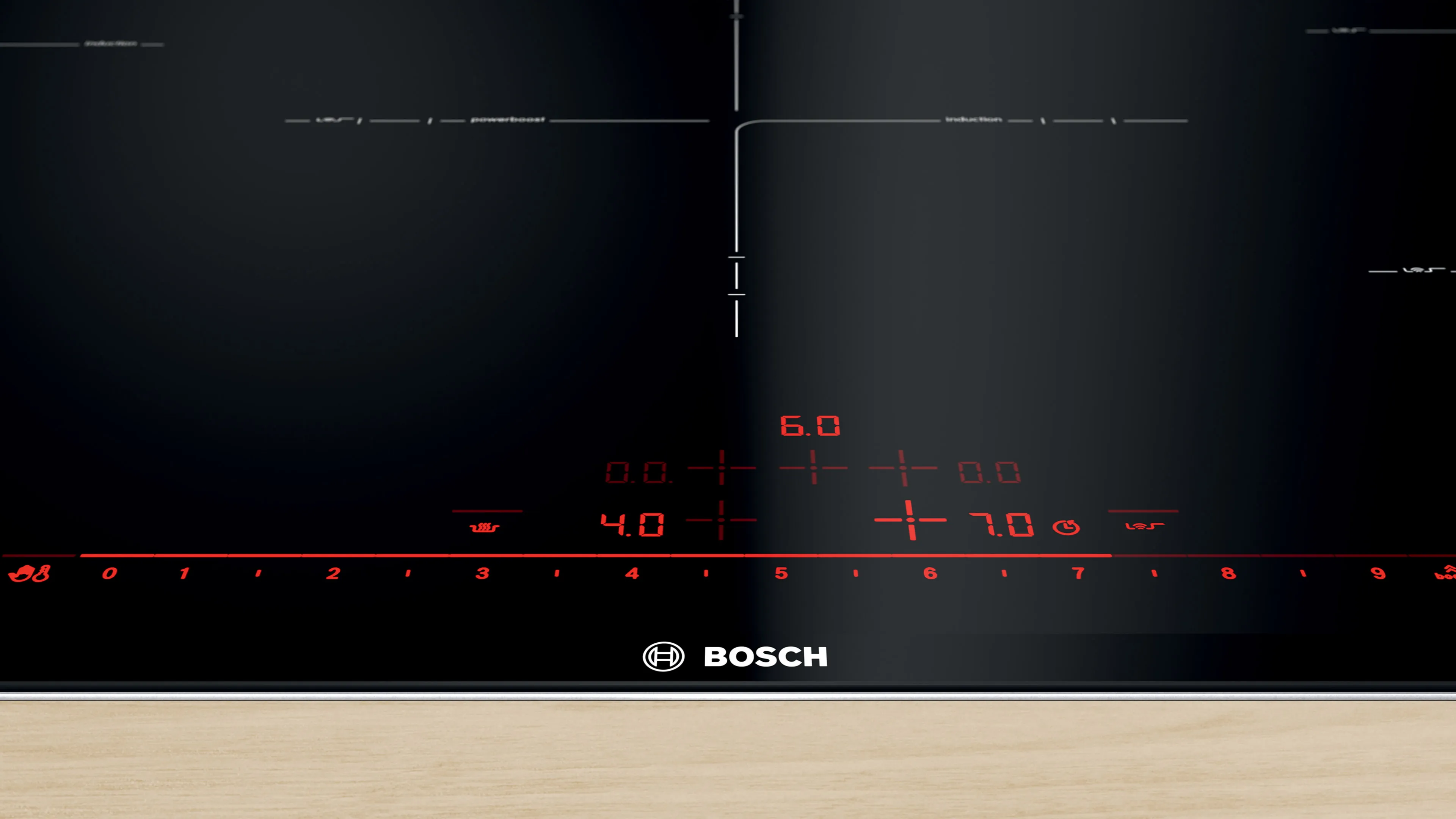 Piano cottura a induzione Bosch con display digitale e controlli di temperatura su una superficie di legno.