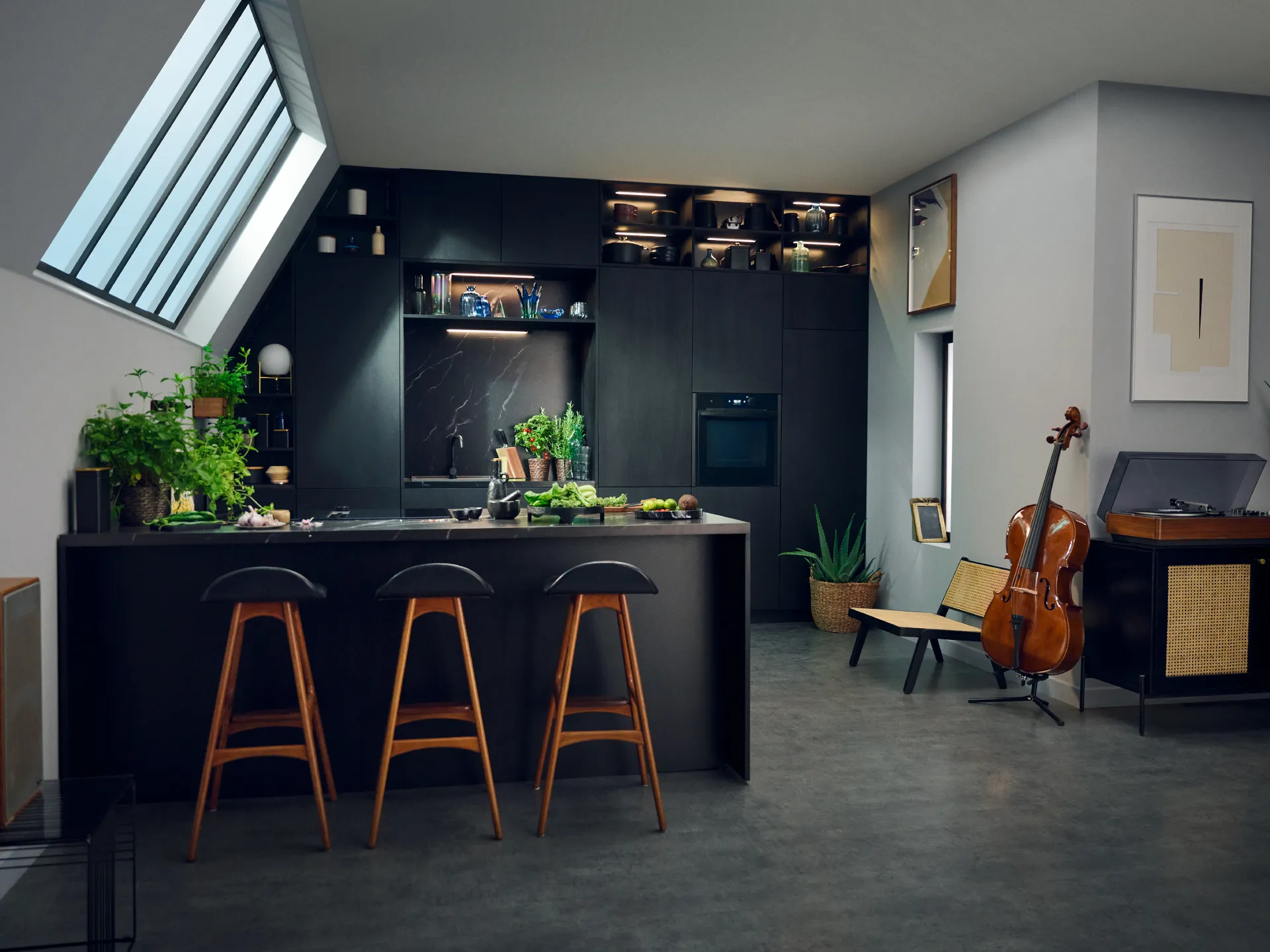 Modern kitchen with black cabinets, wooden countertops, and bar stools. Potted plants and musical instruments visible.