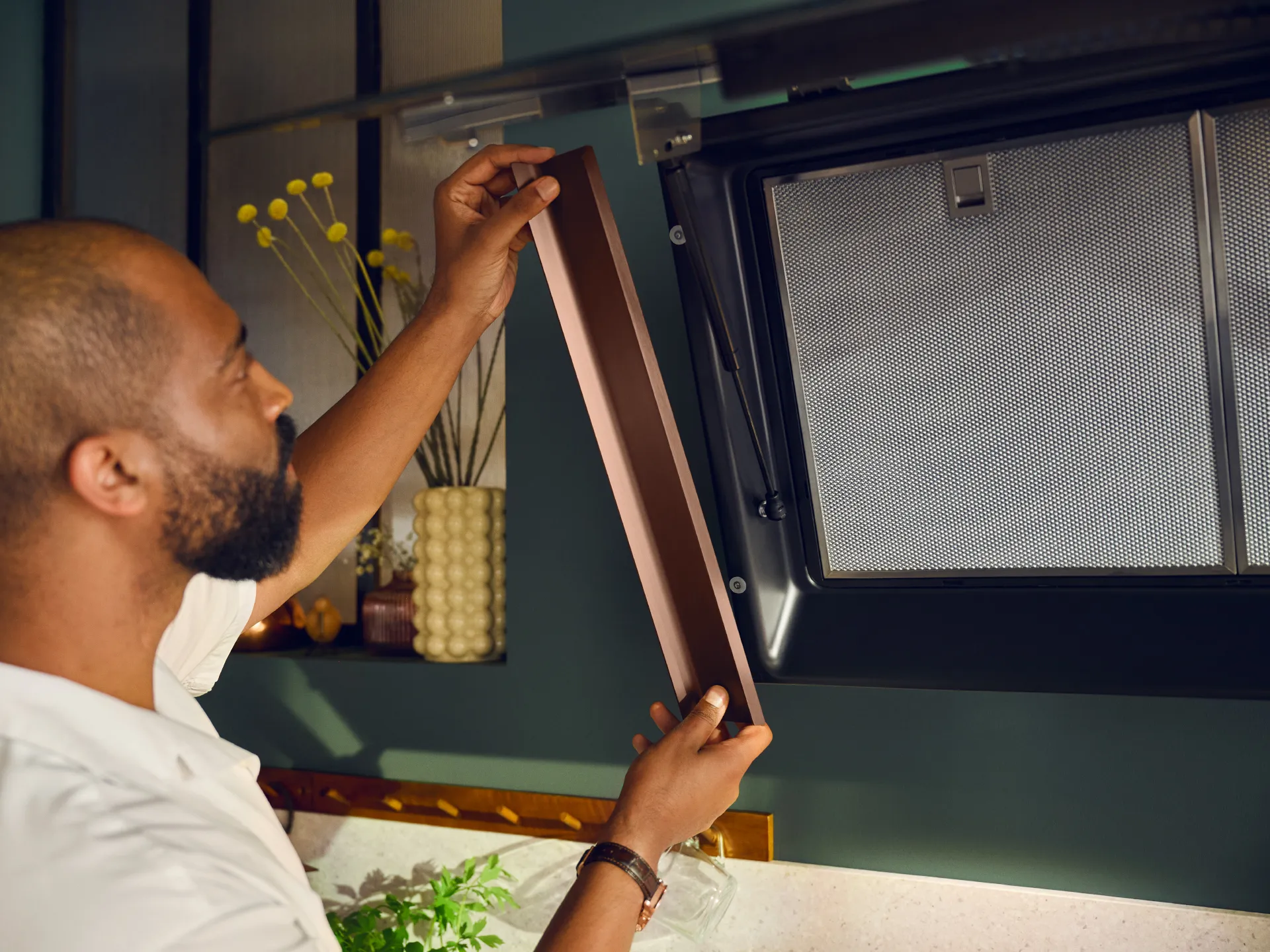 Man adjusting microwave oven in kitchen.