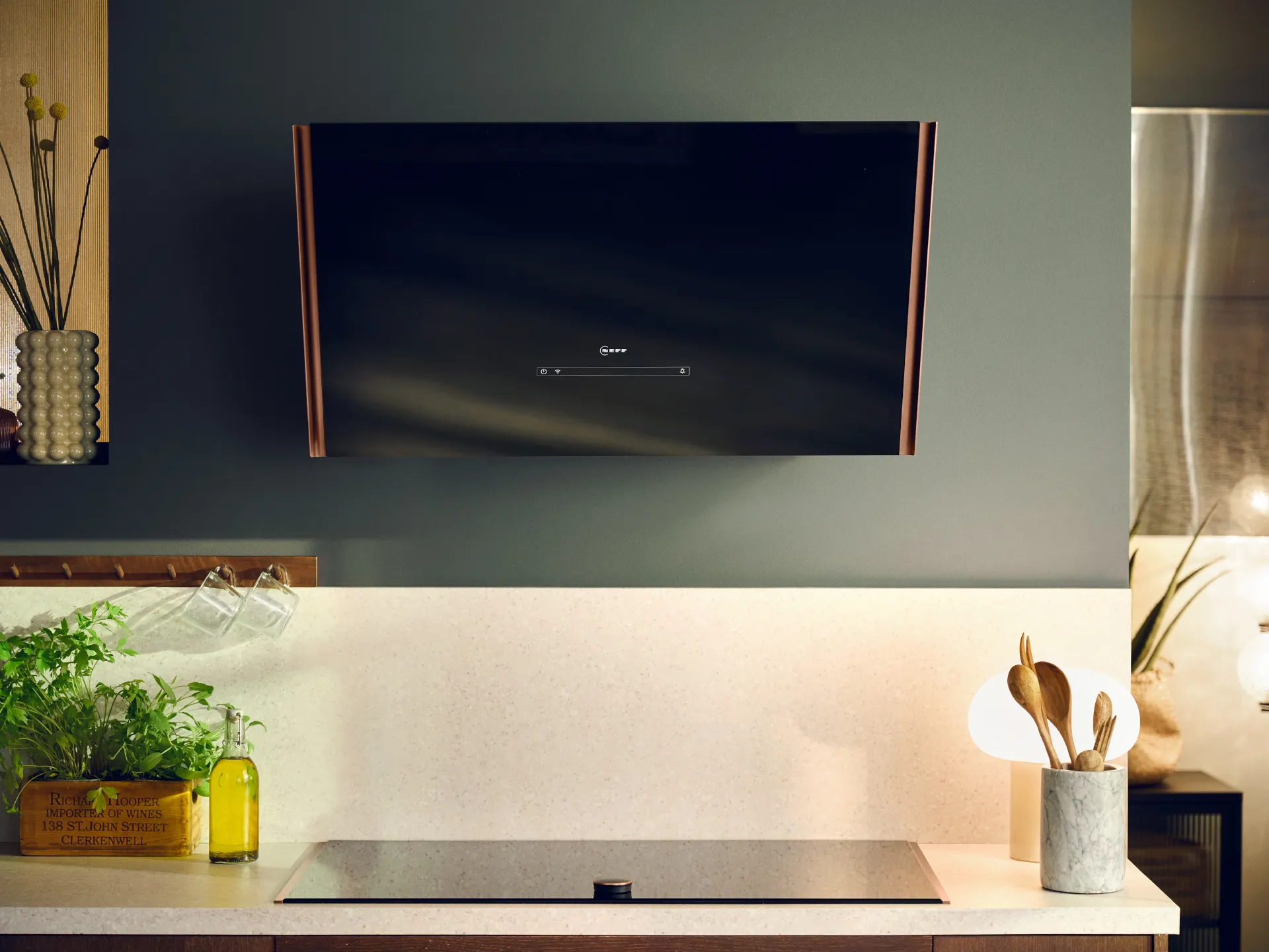 Modern kitchen with TV, plants, cooking utensils, and minimalist decor.