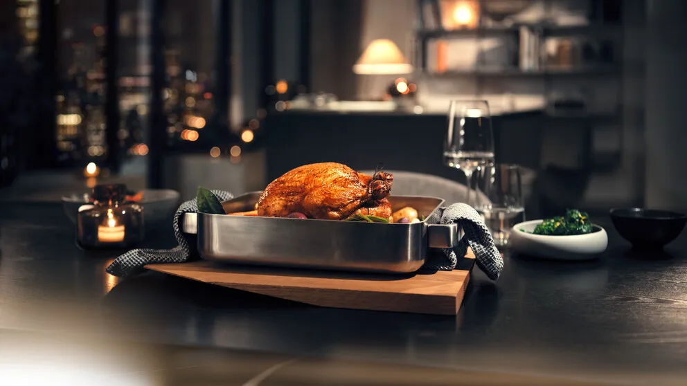 Candle lit dinner on a table with a roast chicken