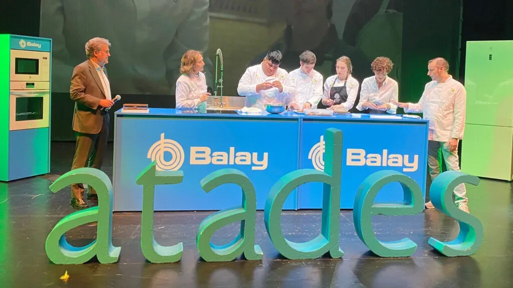 Programa de cocina con el logotipo de Balay, presentador y chefs preparando comida en el escenario. 