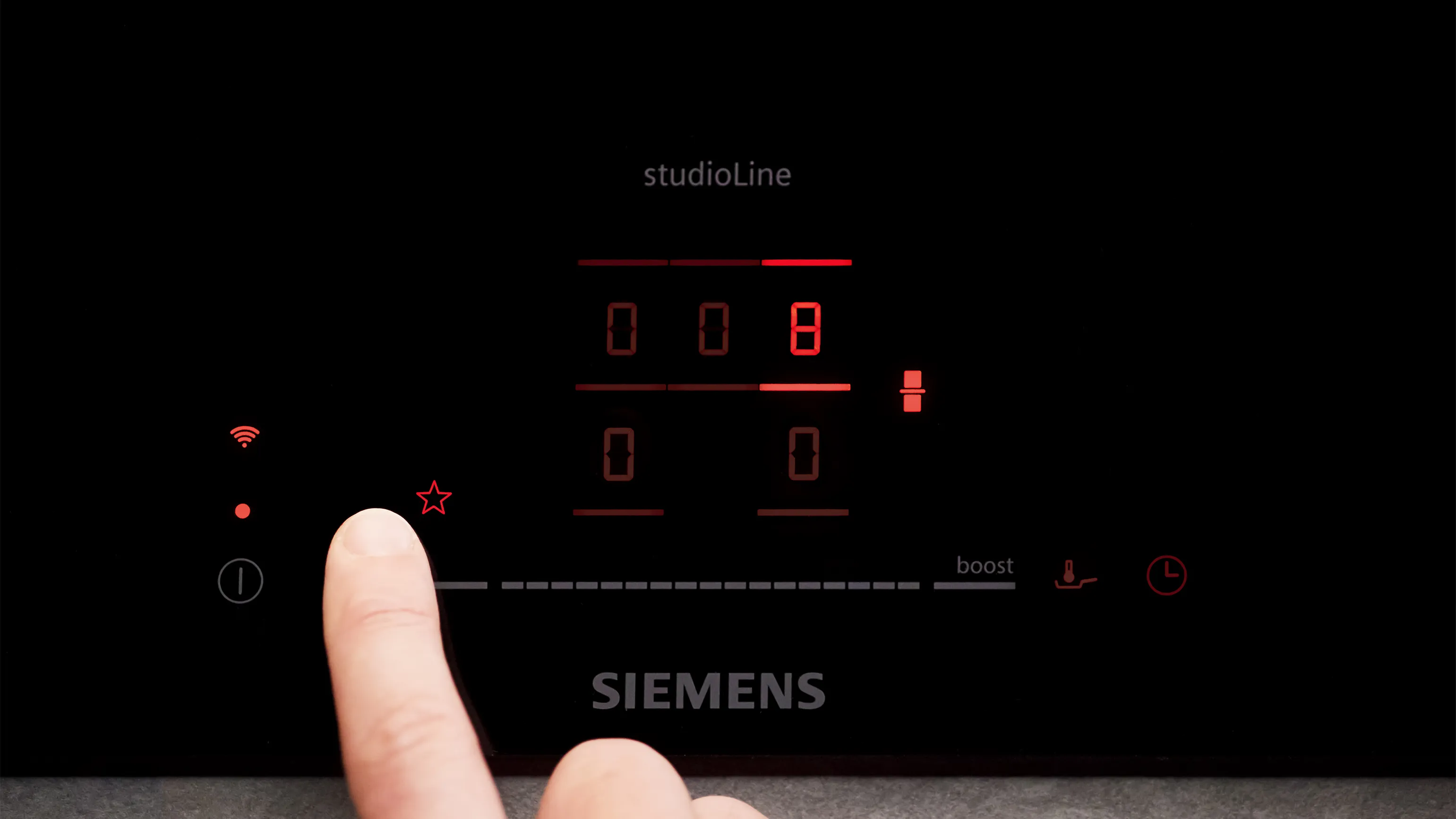 Finger berührende digitale Anzeigetafel von Siemens-Gerät mit roten LED-Anzeigen.