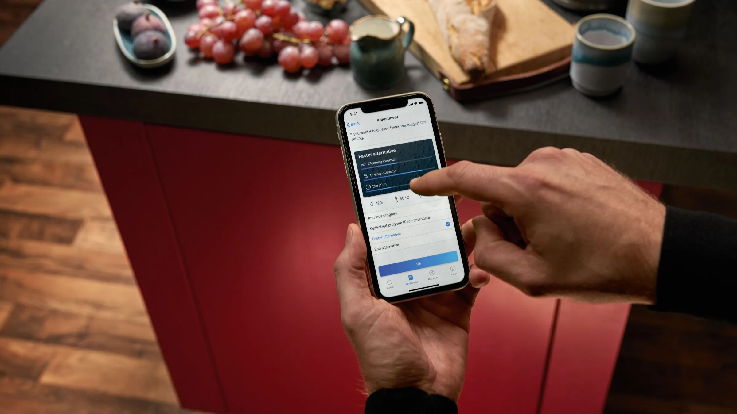 handen bedienen een smartphone in de keuken