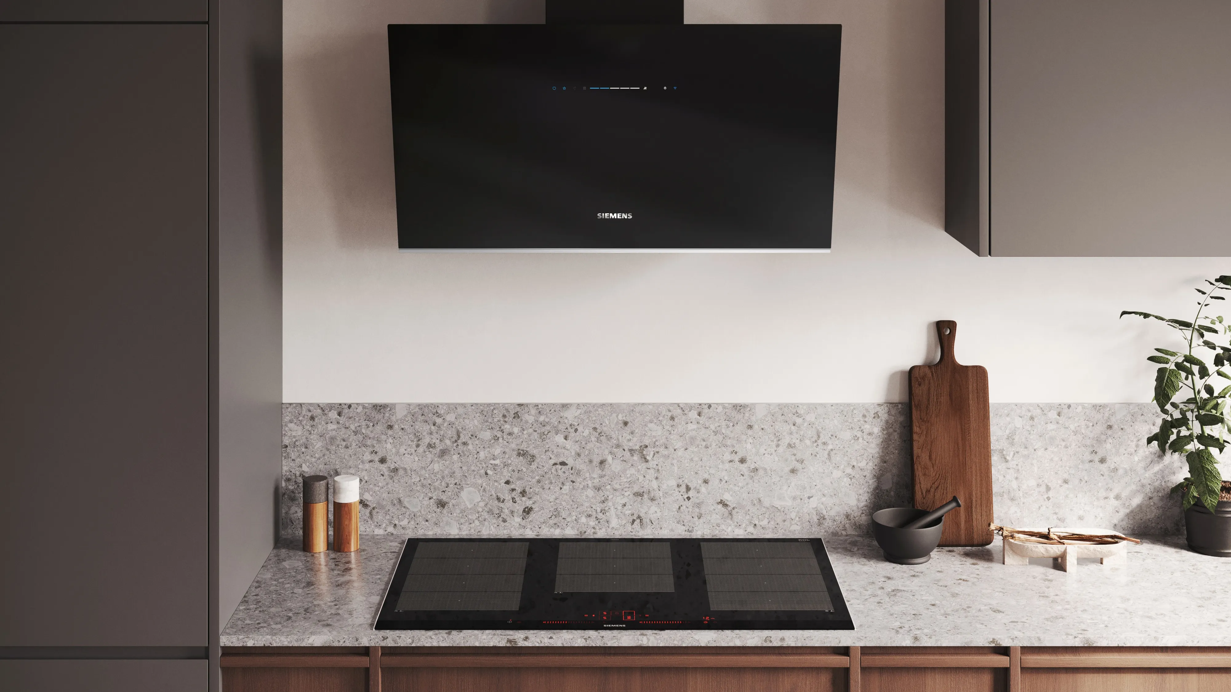 Campana de pared inclinada de color negro instalada en combinación con una placa flexinducción