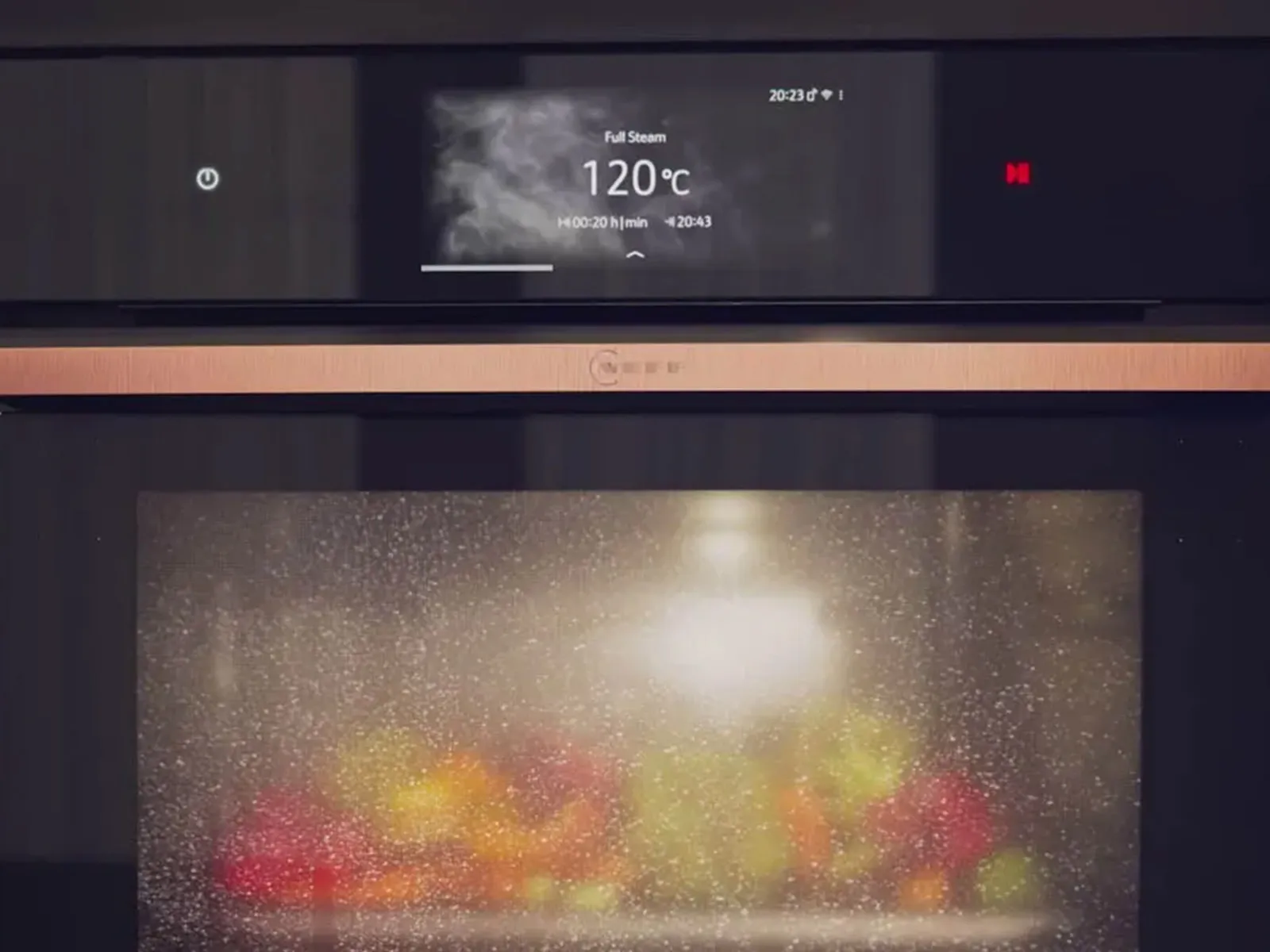 Oven display showing temperature of 120°C, with a blurred, colorful image of food inside the oven.