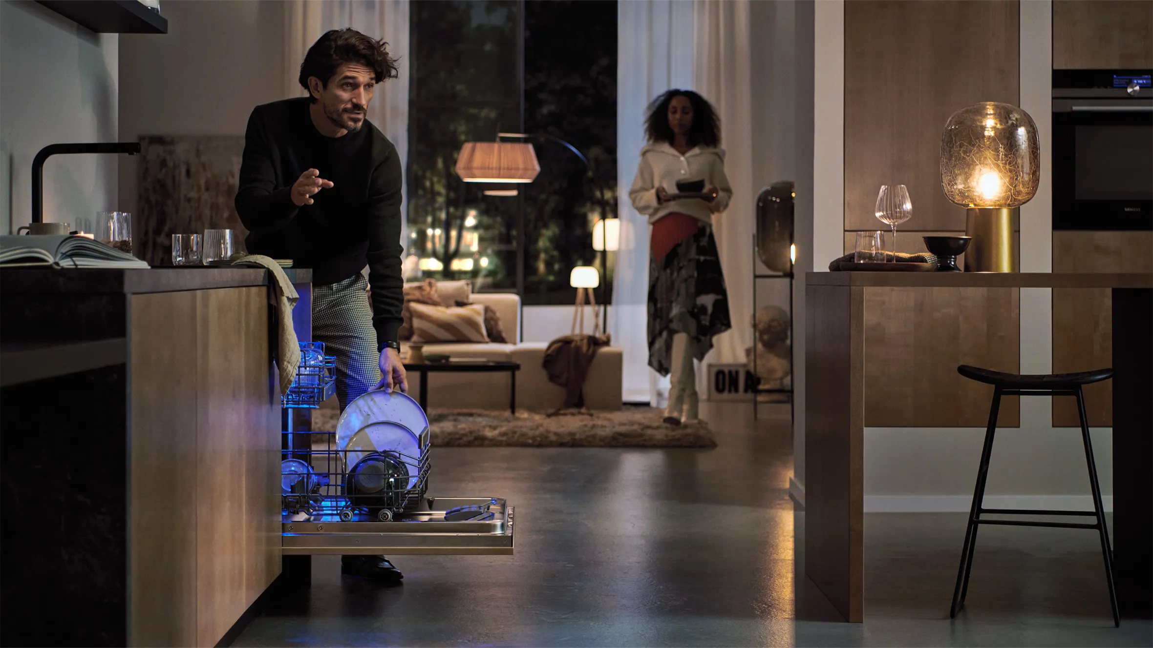 Mann arbeiten Roboter Staubsauger im Wohnzimmer mit Frau in der Nähe stehen.