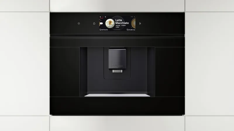 Una varietà di bevande al caffè in tazze di vetro trasparente si trovano su un tavolo sotto un'insegna al neon luminosa "Sempre aperta".