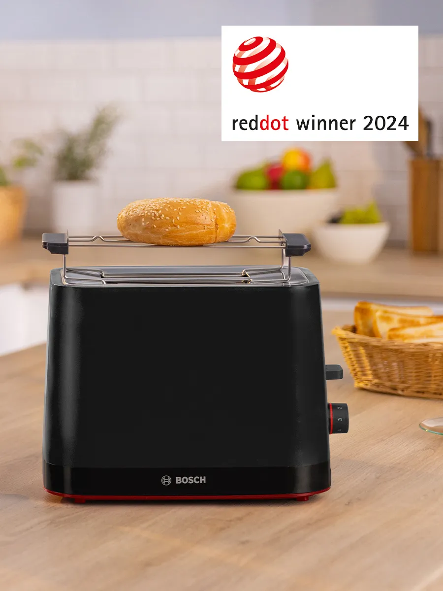 Elegantan crni Bosch toster sa zemičkom posutom susamom koja se tostira, nagrađen Red Dot Winner 2024, na modernom kuhinjskom pultu.