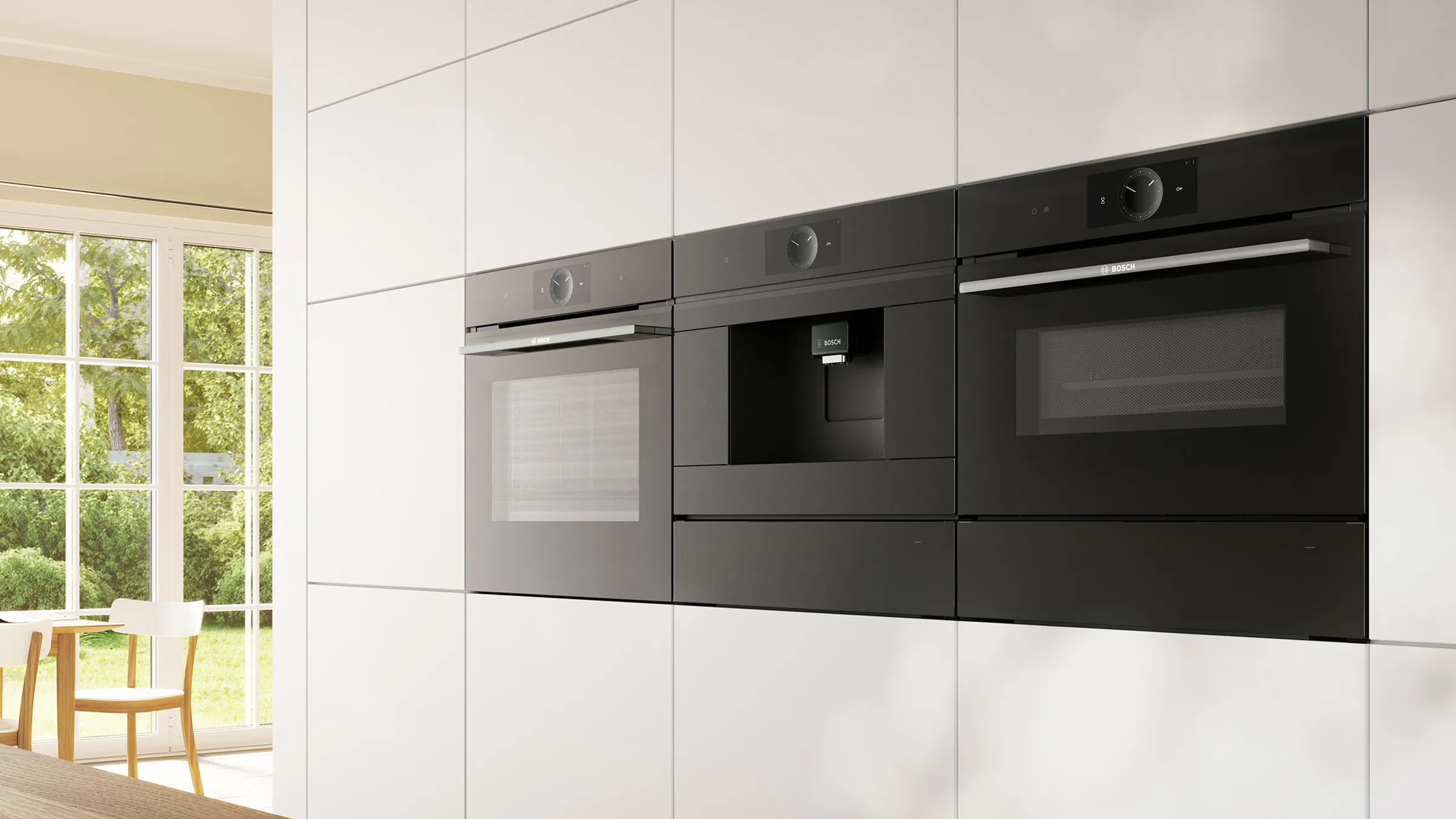Built-in Bosch black glass appliances, including ovens and a coffee centre, integrated into a modern white kitchen wall.