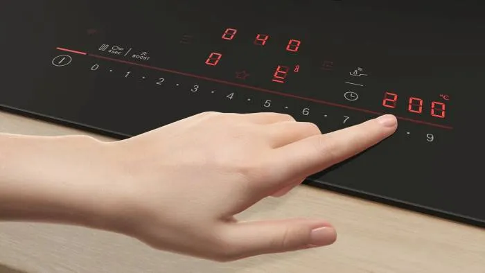 En animerad hand pekar på temperaturkontroll på en induktionshäll från Bosch med funktionen PerfectFry Plus