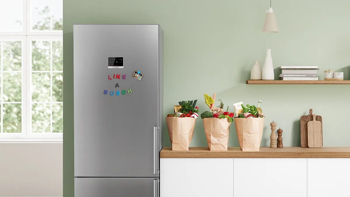 Modern kitchen with refrigerator, shelves, and paper bags filled with fresh produce.