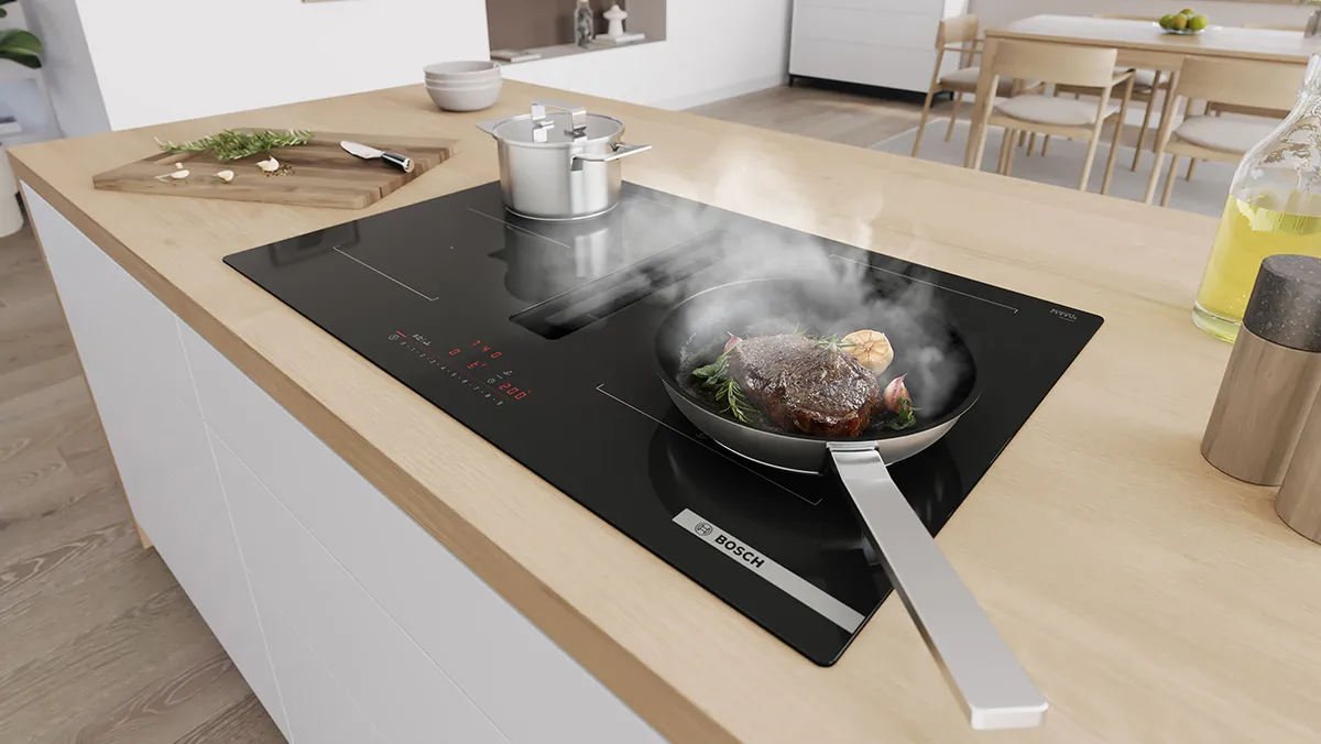 A hot pot and pan on venting induction hob that's sucking away steam.
