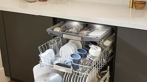 Open Bosch dishwasher with two loaded racks of dishes, glasses, and cutlery.