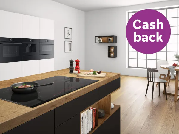 Modernt kök med svarta och vita skåp, träbänkskiva och en "Cash back" reklamöverlägg.