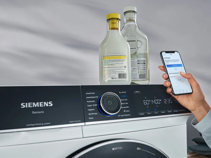 Siemens iSensoric Waschmaschine mit intelligentem Dosiersystem und Waschmittelflaschen, bedienbar per Smartphone-App.