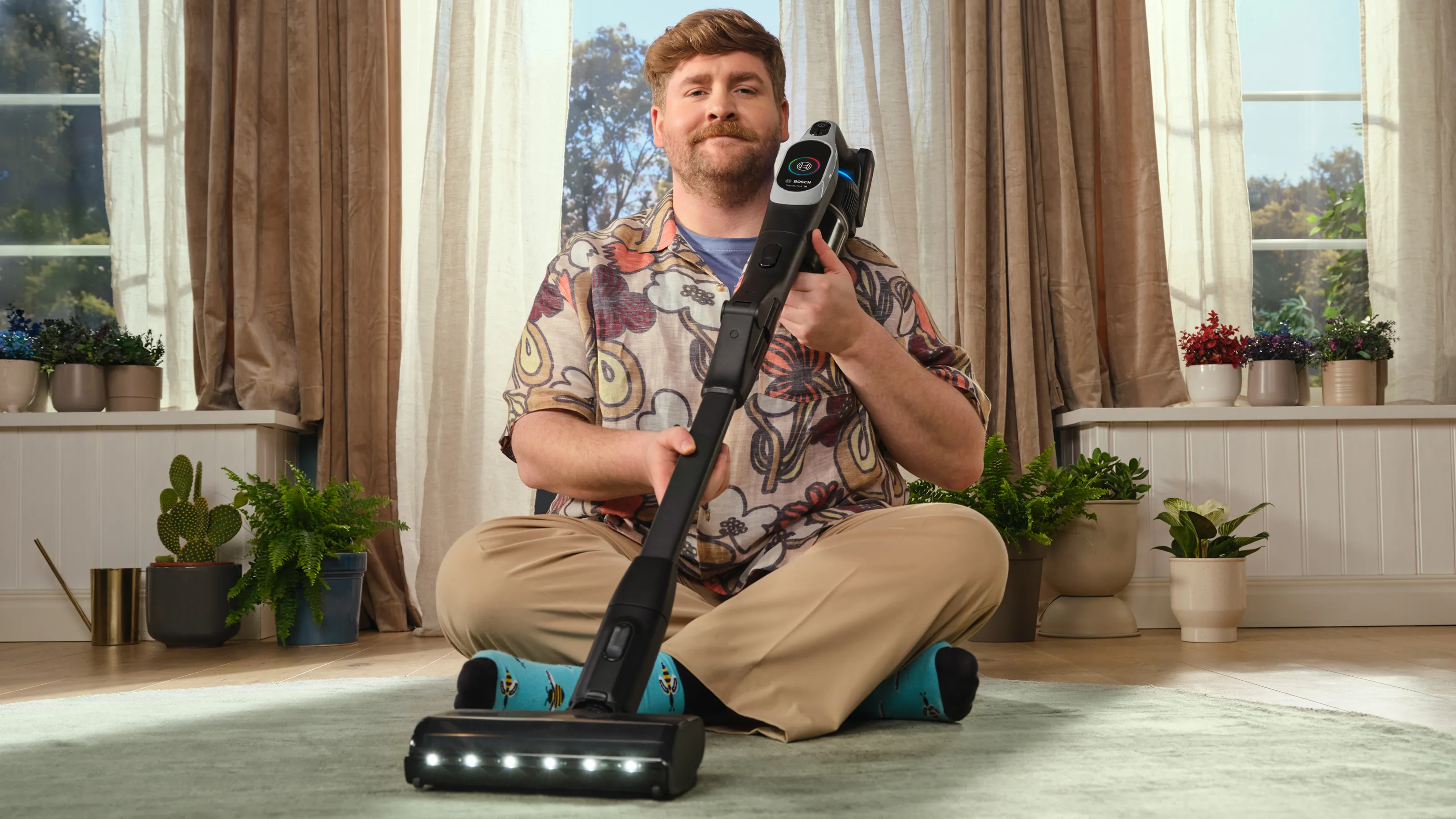 Man sitting cross-legged on a carpet with the Unlimited in his lap, leaning against his shoulder.