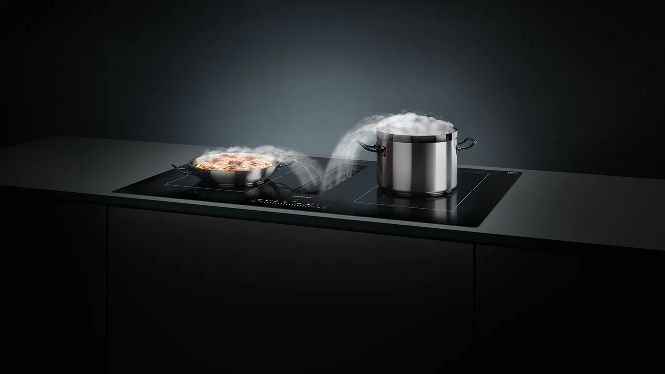 כיריים אינדוקציה של סימנס עם אוורור משולב, מחבת אידוי, וברקע סידור אוכל מודרני.