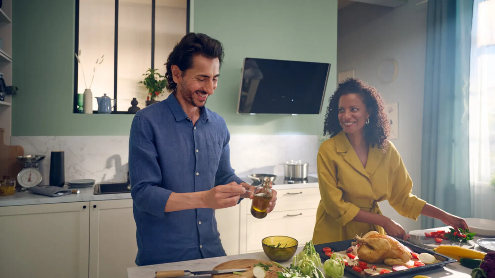 A man and woman cooking together in a kitchen, preparing food with utensils and ingredients.