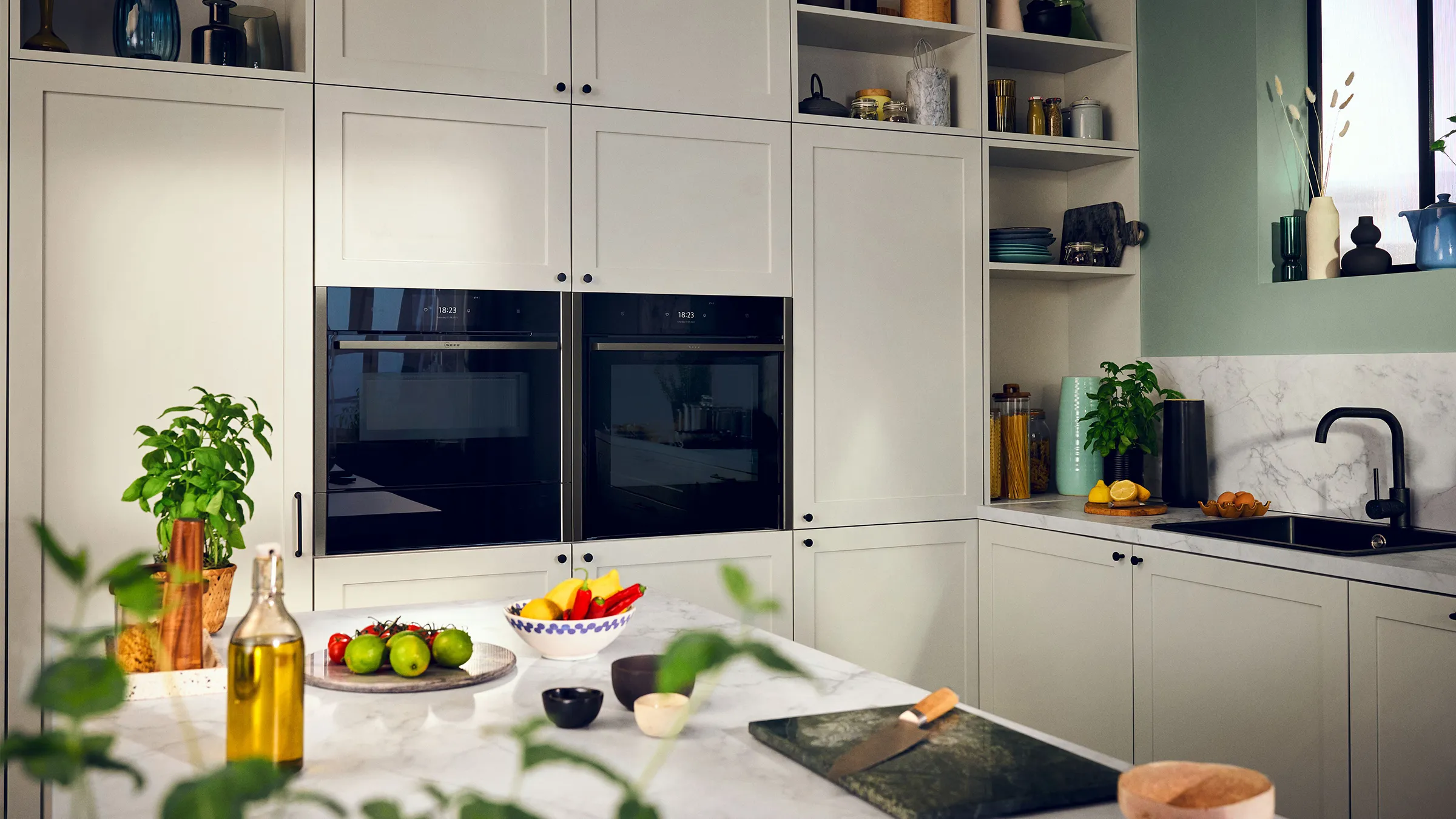 A modern kitchen featuring white cabinets and sleek black appliances, creating a stylish contrast.