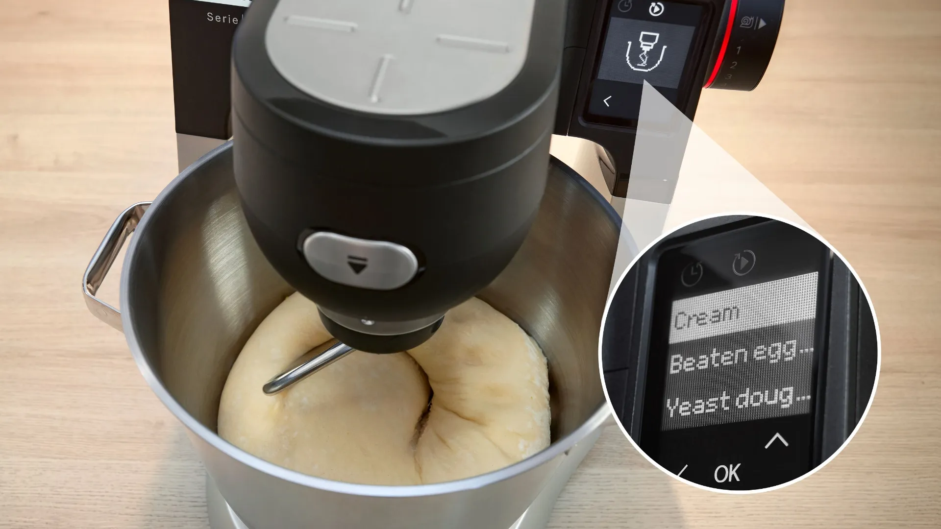 An electric stand mixer is shown in a stainless steel bowl with dough being mixed. The mixer is equipped with a digital display that indicates options such as "Cream," "Beaten egg," and "Yeast dough."