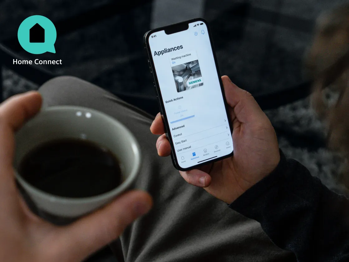 Vernetzte Waäschepflege.Smartphone mit Siemens Hausgeräte App.