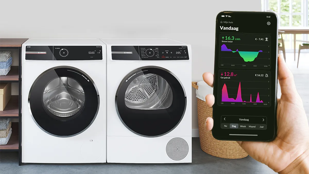 Une paire de machine à laver et sèche-linge Bosch à côté d'un smartphone affichant des statistiques de consommation d'énergie dans une salle de lavage moderne.