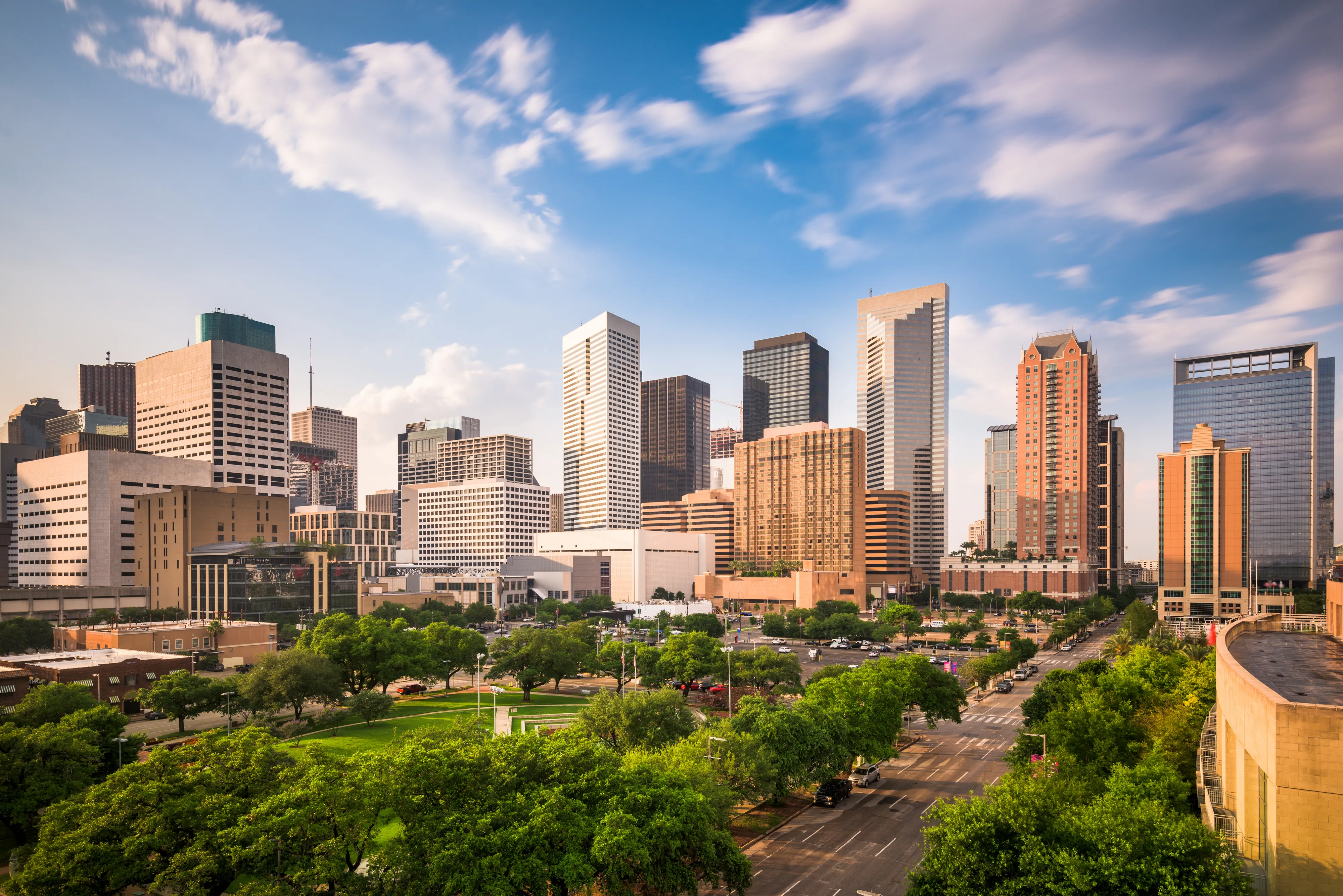 Skyline of Houston, Texas with varied high-rise buildings under a partly cloudy sky.