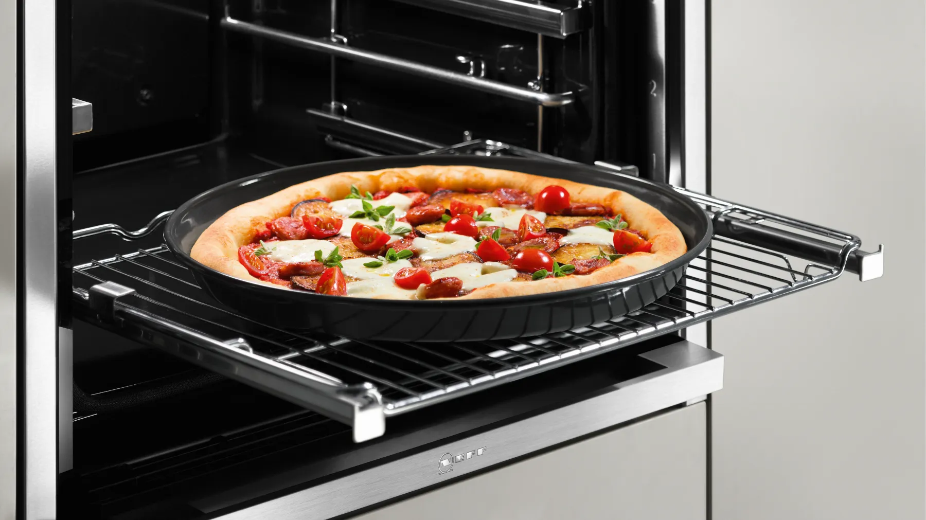 Frisch gebackene Pizza wird aus dem NEFF Backofen genommen