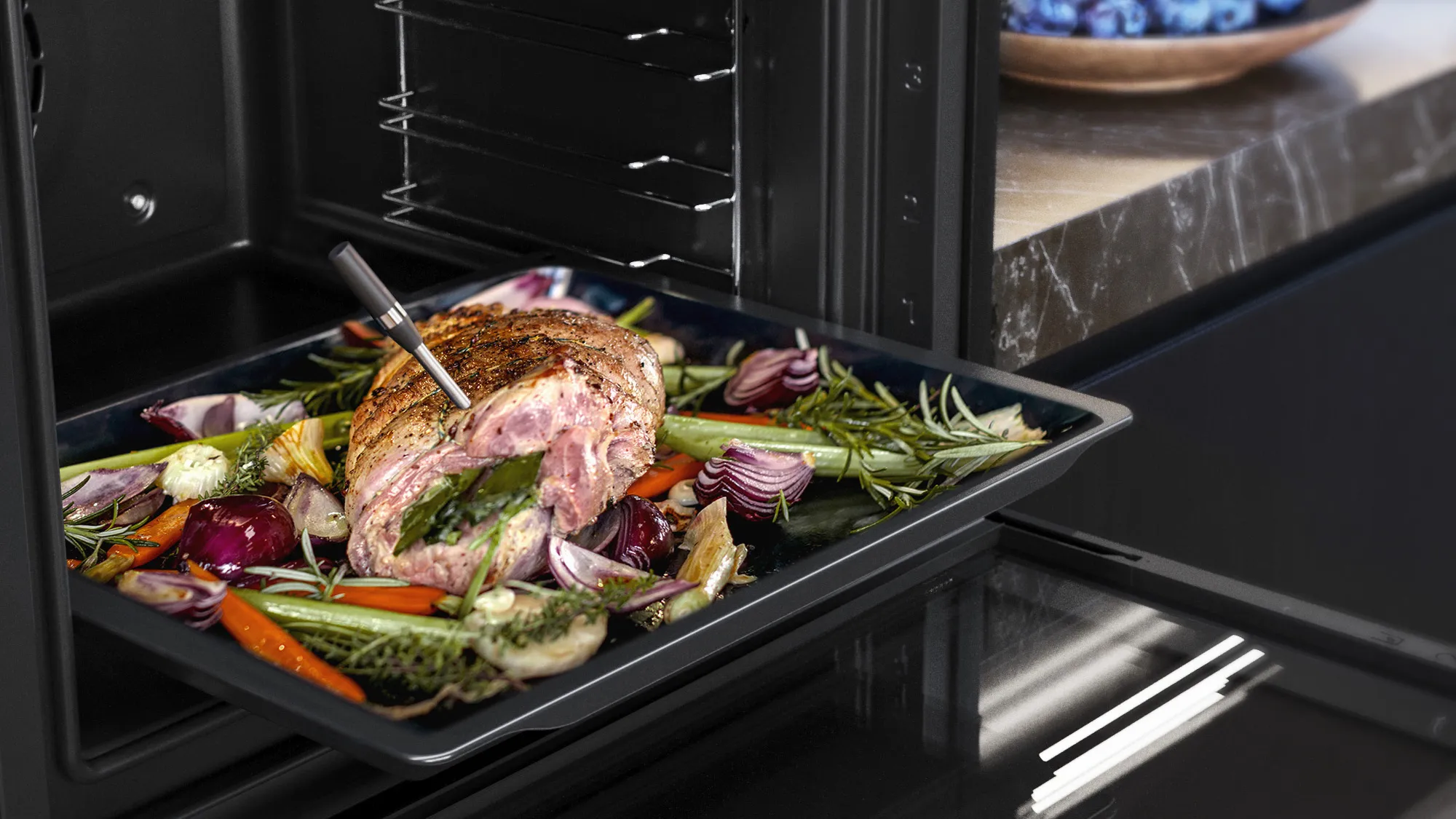 Rôti cuit avec herbes et légumes dans un four moderne Siemens, avec thermomètre inséré. 