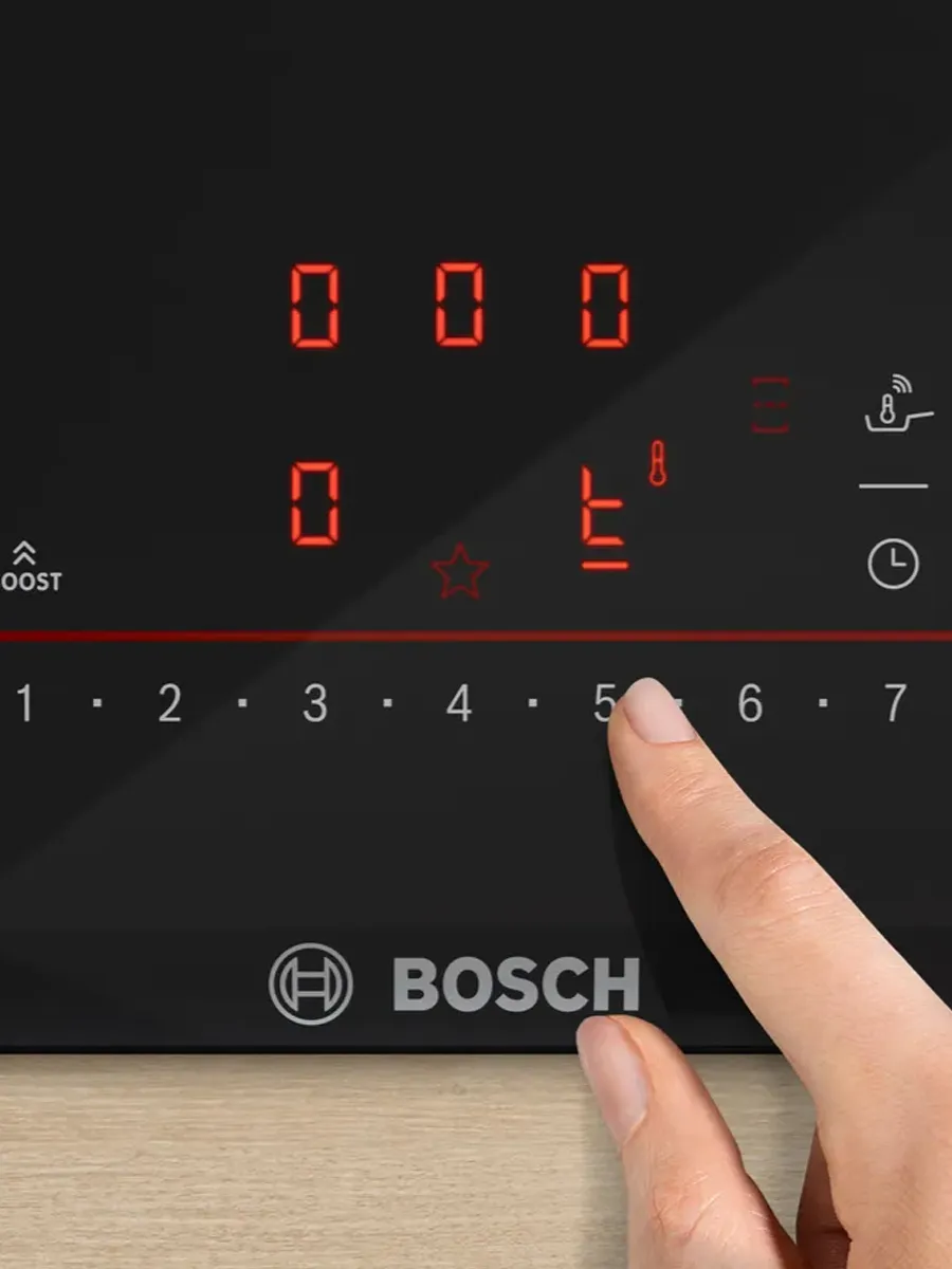 Bosch appliance control panel with digital display and touch controls on a wooden surface.