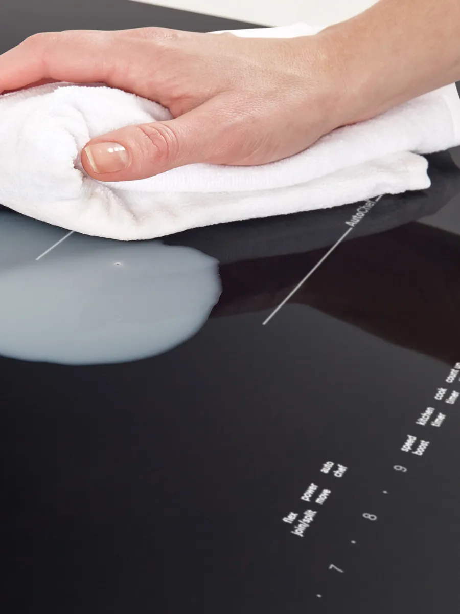 Hand resting on white towel on black surface, with medical equipment visible.