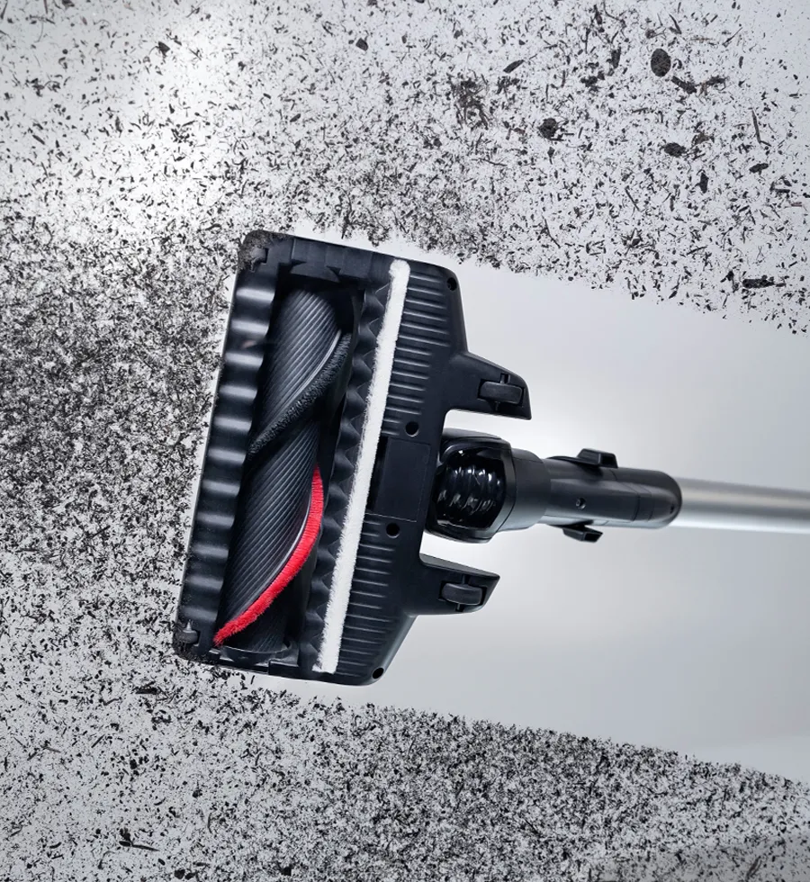 Vacuum cleaner attachment with rotating brush on a textured background.