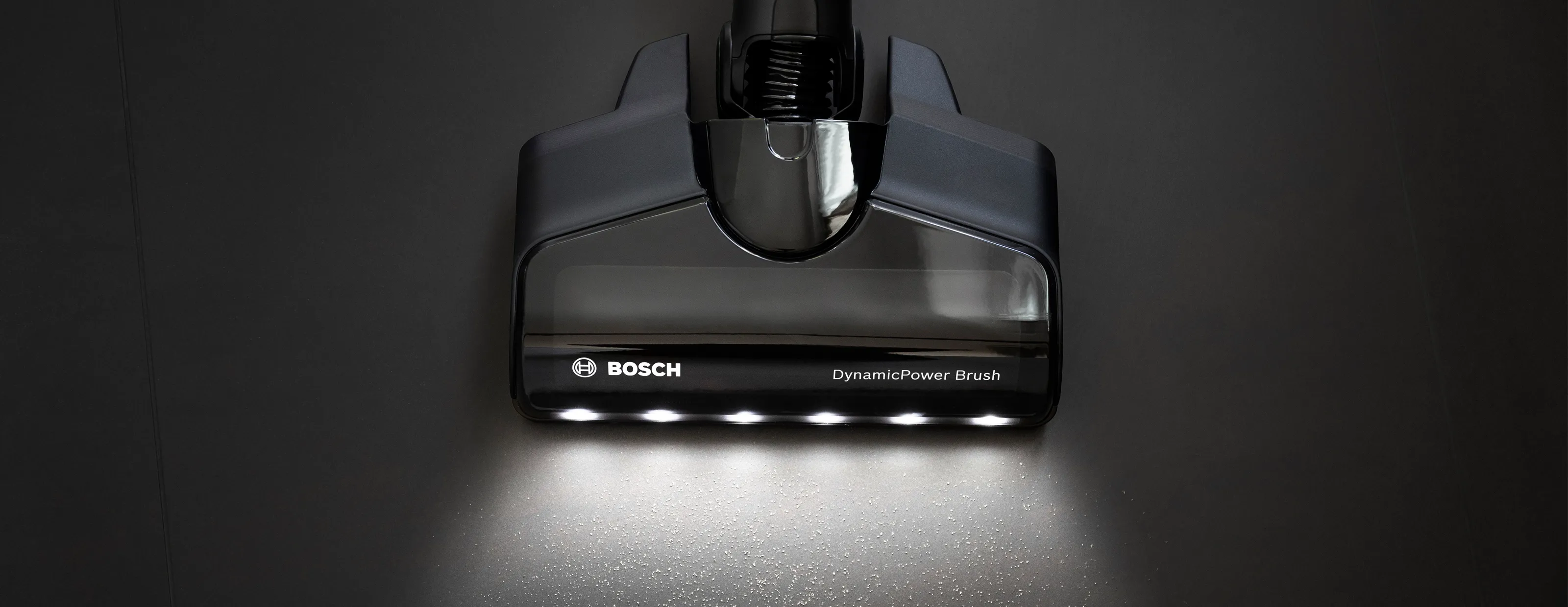Bosch vacuum cleaner nozzle with LED lights on a dark background.