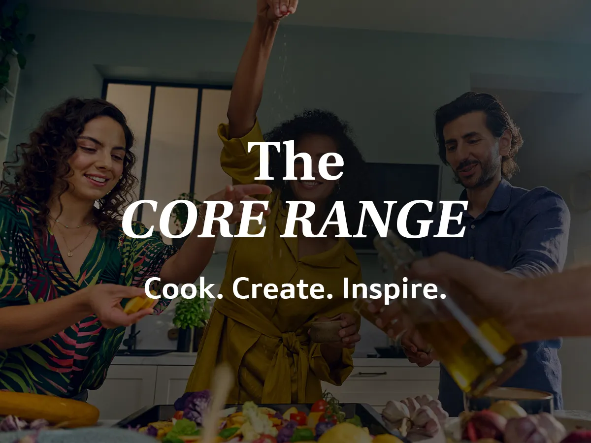 The image shows two people, a man and a woman, cooking together in a kitchen. The text overlay reads "The CORE RANGE: Cook. Create. Inspire."