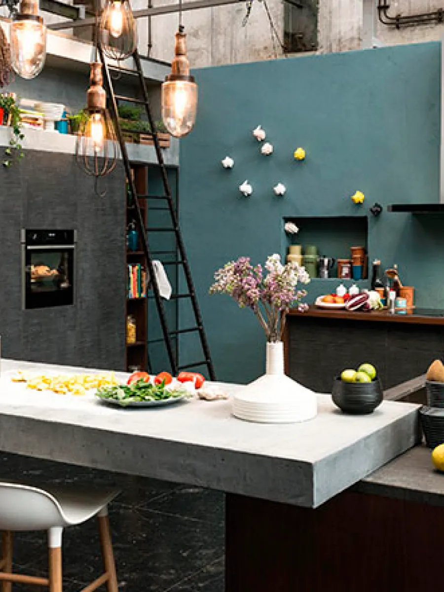 Μια ντιζαϊνάτη κουζίνα με μαρμάρινους πάγκους, έντονα μπλέ και γκρι χρώματα στους τοίχους.