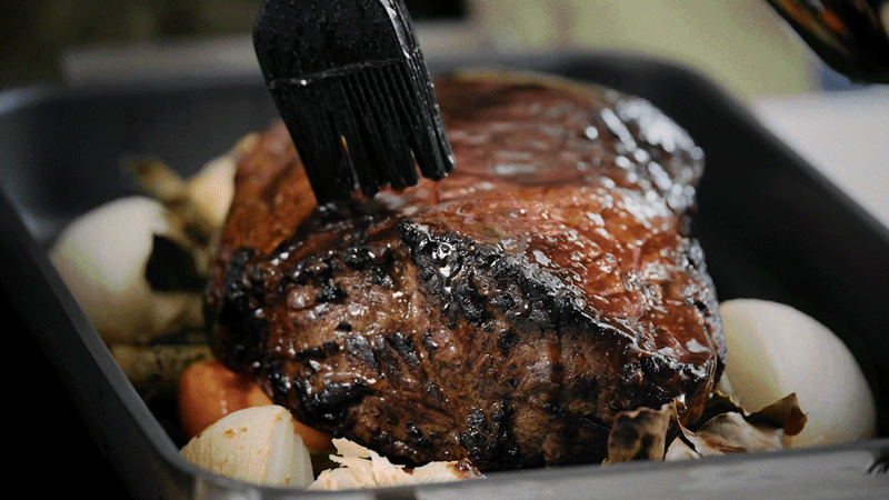 Slicing joint of marmite glazed roast beef