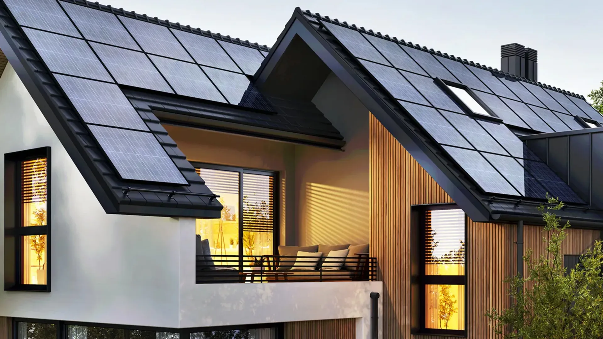 Ein modernes Haus mit großen Solarmodulen auf dem Holzdach und einem gemütlichen Balkon mit bequemen Polstermöbeln.