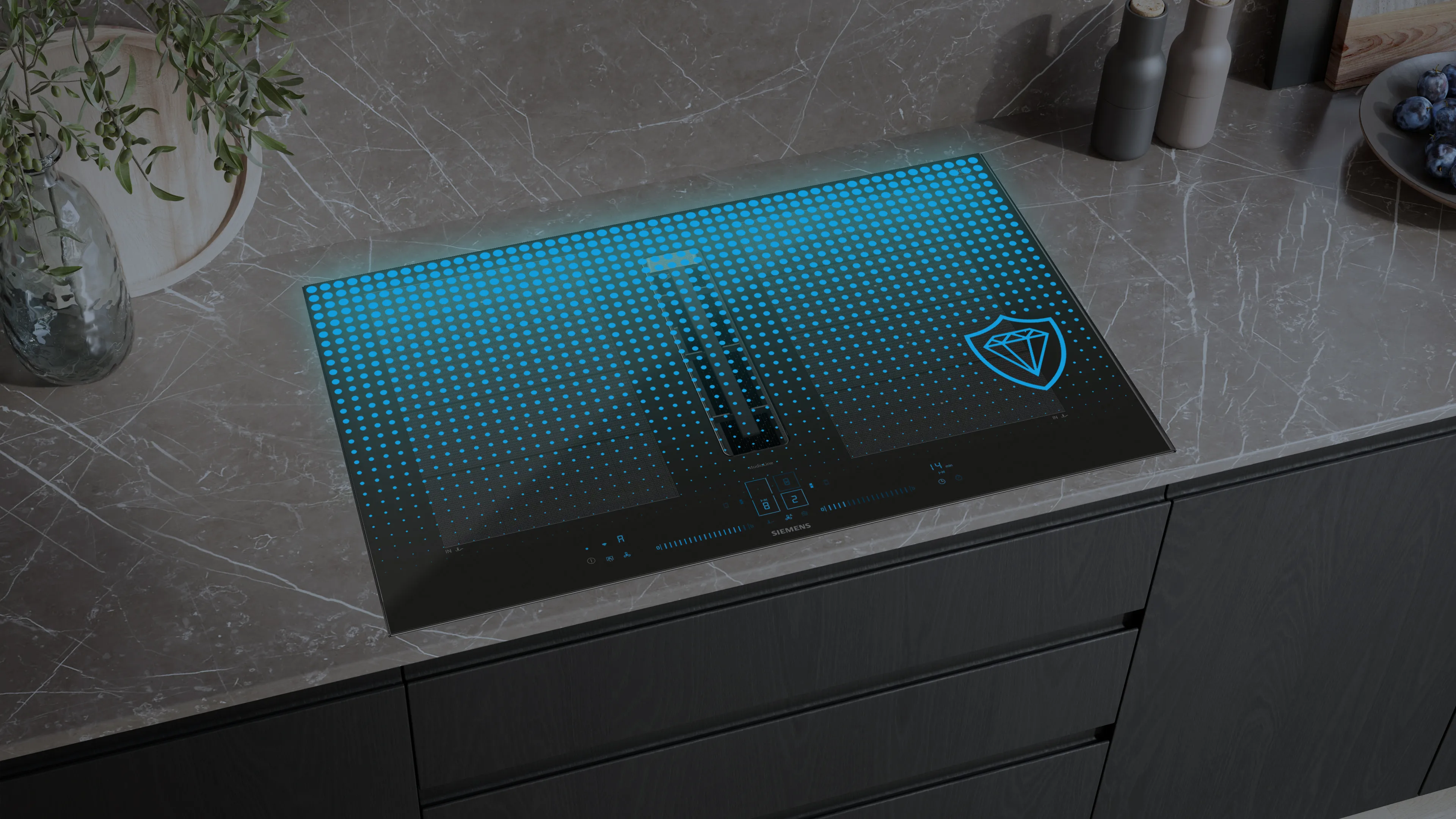 Moderno piano cottura in vetro nero con interfaccia digitale illuminata di blu e icona dello schermo di protezione su un piano di lavoro in marmo grigio.