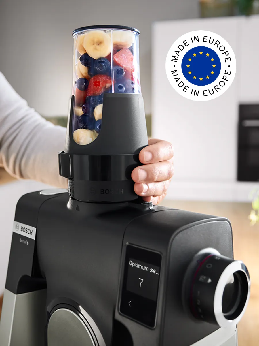 Persoon gebruikt ToGo-fles om fruitsmoothie te maken met de Serie 6 keukenrobot, met het ‘made in Europe’ logo in beeld.