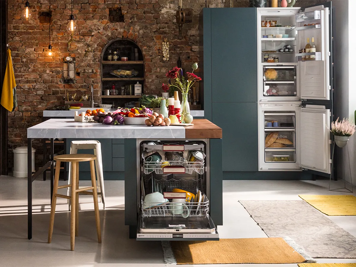 Rustic kitchen with brick walls, wooden island, appliances, and fresh produce on the counter.