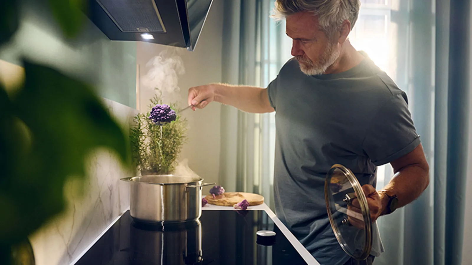 Man cooking using Neff hob and hood