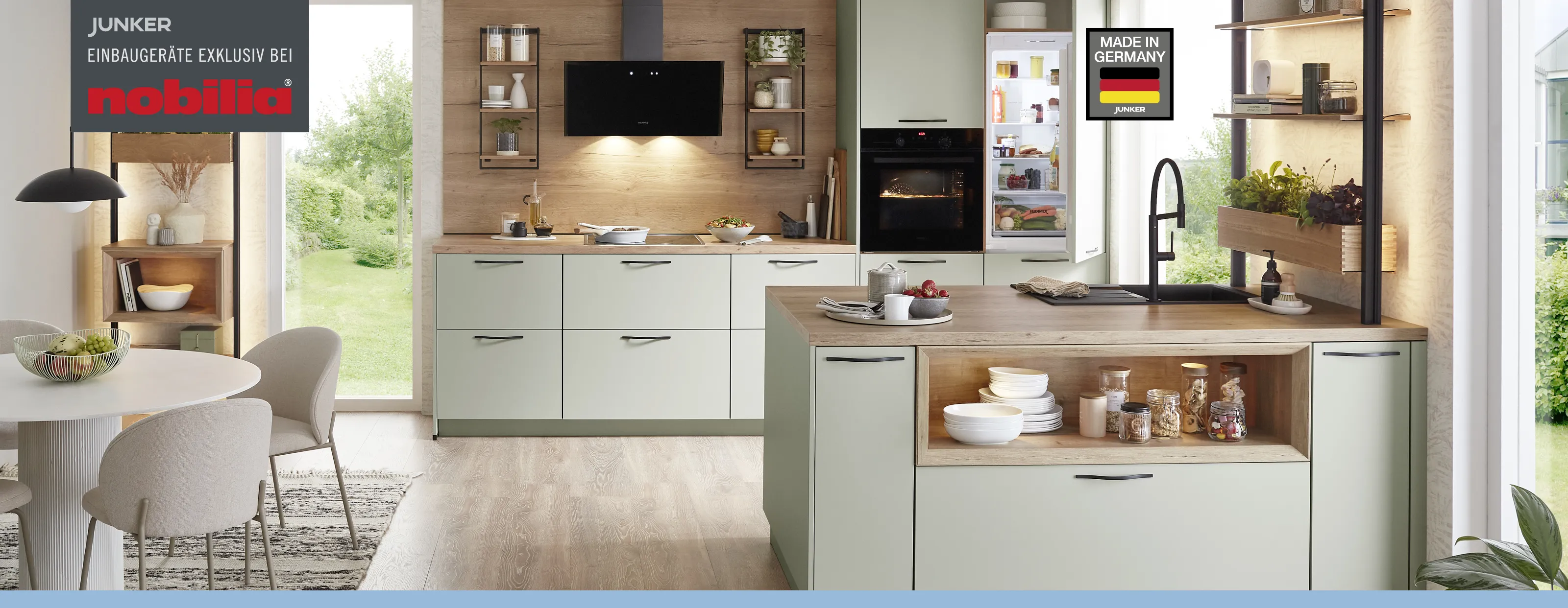 Modern sage green Nobilia kitchen with wood elements and a kitchen island, equipped with Junker built-in appliances.