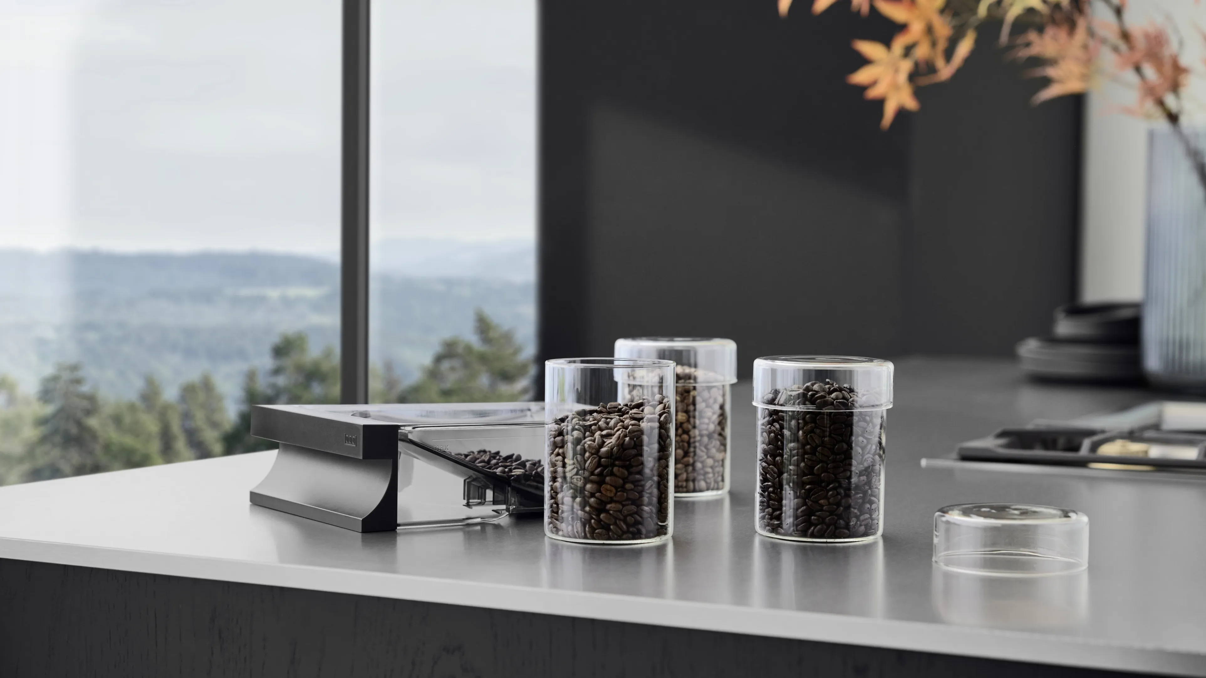 Filling the coffee bean drawer of the Gaggenau Expressive series fully automatic espresso machine from a selection of different types of coffee stored in glass containers